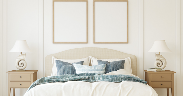 Elegant Strand hotel bedding: king bed with white percale sheets, triple-sheeted duvet, navy pillows, twin nightstands and lamps in a master bedroom.
